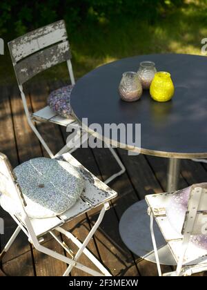 Stühle und runder Tisch auf Holzterrasse im Garten des Wohnhauses, Dänemark Stockfoto