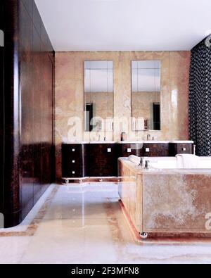 Rosa und burgunderrot Badezimmer mit Spiegeln über Waschbecken im Wohnhaus, Großbritannien Stockfoto