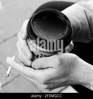 London, Großbritannien, März 17 2021, Nahaufnahme eines jungen Mannes, der eine Takeaway-Tasse von Cafe Nero Coffee hält Stockfoto