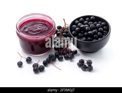 Aronia Marmelade und frische Aronia Beeren auf weißem Hintergrund Stockfoto