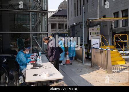 Hongkong, Hongkong. März 2021, 17th. Medizinische Mitarbeiter, die persönliche Schutzanzüge tragen, unterstützen die Mitarbeiter von HSBC an einer temporären COVID-19-Teststation außerhalb ihres Hauptbüros in Hongkong. Die Hauptniederlassung von HSBC Holdings Plc in Hongkong wurde bis auf weiteres geschlossen, nachdem mehrere positive Coronavirus-Fälle (COVID-19) im Gebäude gefunden wurden. Kredit: SOPA Images Limited/Alamy Live Nachrichten Stockfoto