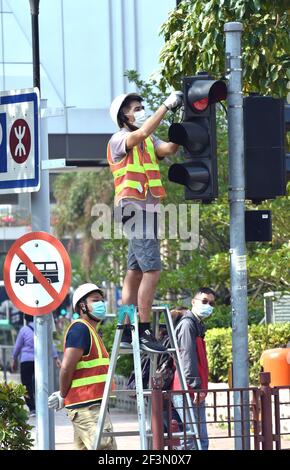 Hongkong, China. März 2021, 17th. Ein Arbeiter repariert eine Ampel in Hongkong, Südchina, 17. März 2021. Das Zentrum für Gesundheitsschutz in Hongkong (CHP) meldete am Mittwoch 11 weitere bestätigte Fälle von COVID-19, insgesamt 11.340. Kredit: Lo Ping Fai/Xinhua/Alamy Live Nachrichten Stockfoto