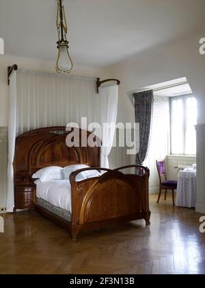 Holzbett mit Bettdach im Schlafzimmer in Französisch Haus Stockfoto