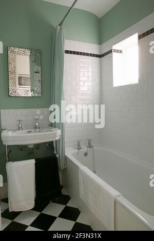 Ein traditionelles Badezimmer mit grünen Wänden und weißen Keramikfliesen. Stockfoto