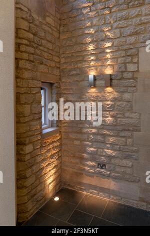 Merton College, University of Oxford, Hörsaal und Empfangsbereich. Detail der beleuchteten Steinwand und versenkten Boden Aufheller. Stockfoto