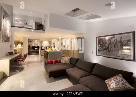 Innenarchitekt im Besitz Familienhaus in Wandsworth. Küchenbereich in geteilter Höhe mit Blick auf den Arbeitsbereich. Großer Familien-Sitzbereich und zentrale Insel Stockfoto