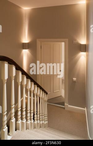 Innenarchitekt im Besitz Familienhaus in Wandsworth. Treppe mit Holzspindeln und in der Ecke montierten oben-unten Feuerzeugen Stockfoto