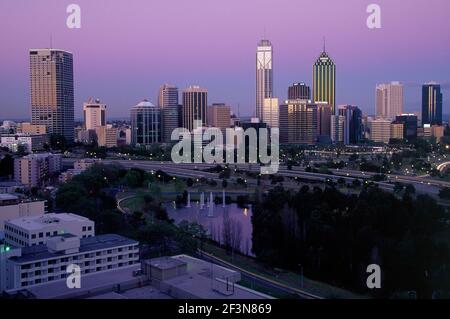 Blick vom King's Park auf die Skyline der Stadt. Nacht. Violetter Himmel. Hohe Gebäude. Pool, Springbrunnen. Straße. Stockfoto