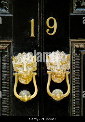 Die traditionellen Eingangstüren in London haben große Ziffern, die die Hausnummer angeben, und häufig große Messing-Türklopfer. Stockfoto