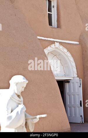 Die Statue des Heiligen Franziskus vor dem Eingang zur Kirche des Heiligen Franziskus, Ranchos de Taos, New Mexico, USA. Stockfoto