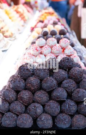 Stall mit traditionellen Schokolade festliche Süßigkeiten zum Verkauf auf dem Markt. Verschiedene Marzipan Süßigkeiten Kugeln auf den Regalen. Stockfoto