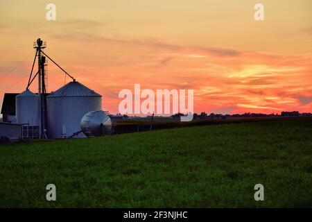 Burlington, Illinois, USA. Die Sonne untergeht über Lagersilos auf einer Farm im Mittleren Westen der Vereinigten Staaten. Stockfoto
