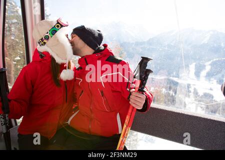 Fröhliche Freunde auf dem Skilift fahren auf verschneiten Berg Stockfoto