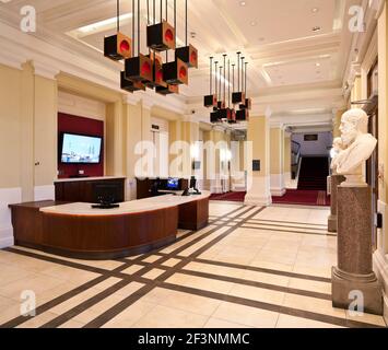 Paisley Town Hall. Ein Gebäude aus dem 19th. Jahrhundert, renoviert, klassische Büsten um einen Rezeptionsbereich. Moderne Lampen hängen von der Decke über der Rezeption Stockfoto