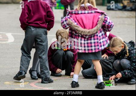 Grundschüler spielen auf einem Schulhof in einer Pause zwischen den Unterrichtsstunden. Stockfoto