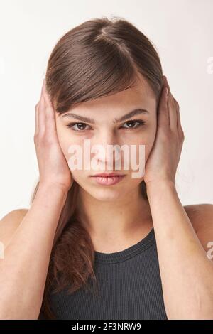 Porträt einer schön aussehenden Frau bedeckt ihre Ohren Close Nach oben Stockfoto