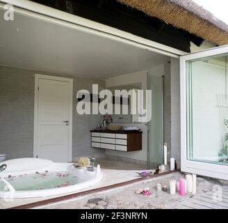 Sommer Idylle auf dem Land. Ein Badezimmer. Rose betals schwimmend in der Badewanne. Stockfoto