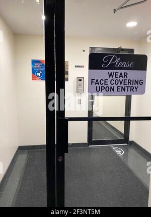 Eingangstür mit bitte tragen Gesichtsmaske Schild, Queens, New York Stockfoto