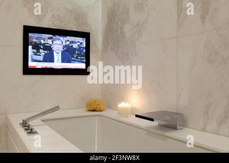 Ein luxuriöses Badezimmer in ein zentrales London Apartment in Knightsbridge. TV-Bildschirm an der Wand. Stockfoto