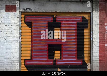 Ben Eine. Street-Art, eine große anfängliche E auf Metall Scrollen Fensterläden gemalt. Stockfoto