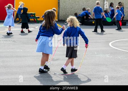 Grundschüler spielen auf einem Schulhof in einer Pause zwischen den Unterrichtsstunden. Stockfoto