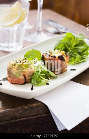 Geröstete Feigen in parmaschinken mit Blauschimmelkäse eingewickelt Ein Beilagensalat Stockfoto