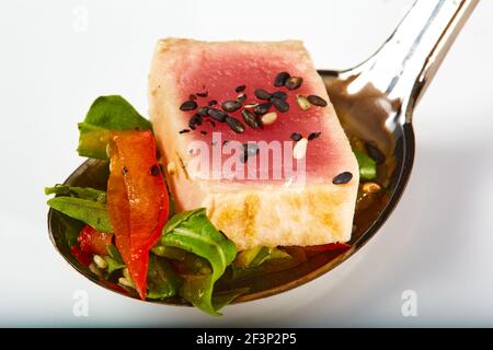 Nahaufnahme von seltenen gebratener Ahi-Thunfisch Scheiben mit frischem Gemüse Salat auf einen Teller. Flache dof Stockfoto