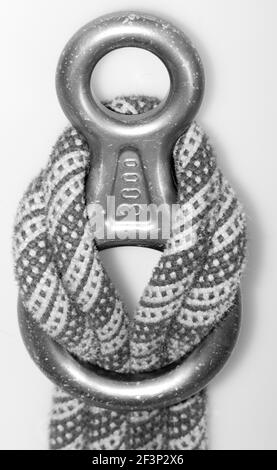 Ein Graustufenfoto eines dicken Seils zum Segeln und Ein Metallstück befestigt Stockfoto