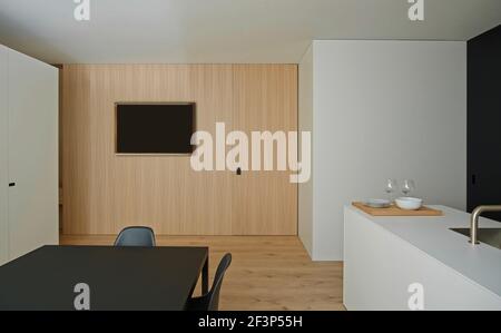 ML House, Barcelona, Spanien. Offene Küche und Essbereich mit moderner Malerei an der Wand. Moderne weiße Kücheninsel mit Waschbecken. Stockfoto