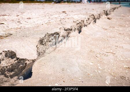 Wellensandstranderosion, erodierte Küste mit gebrochenen Muscheln Muscheln, die im Sommer auf Sanibel Island, Florida am Golf von Mexiko beschossen werden Stockfoto