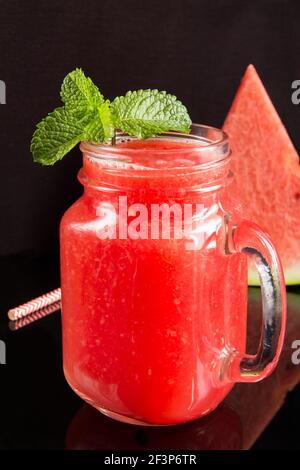 Nahaufnahme von Smoothies aus Wassermelone auf schwarzem Hintergrund. Position vertikal. Stockfoto