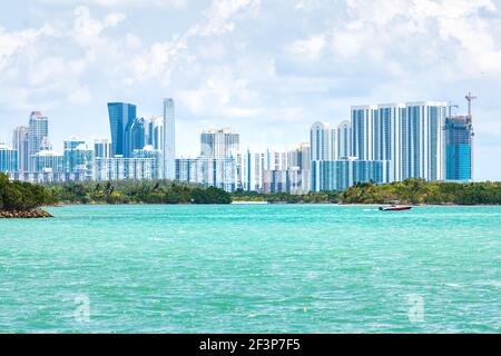 Bal Harbour, Miami Florida mit türkisfarbenem Biscayne Bay Intracoastal Water und Blick auf die Skyline von Sunny Isles Beach mit Motorboot Stockfoto