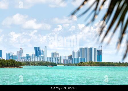 Bal Harbour, Miami Florida mit türkisfarbenem Biscayne Bay Intracoastal Water an der Skyline von Sunny Isles Beach mit Motorboot, Palmenzweig Stockfoto