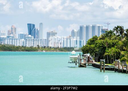 Bal Harbour, Miami Florida Hausdock mit Boot durch hellgrün türkisfarbenes Meer Biscayne Bay Intracoastal Wasser und Stadtbild Sunny Isles Beach Citysca Stockfoto