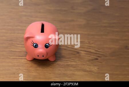 Ton oder Keramik Sparschwein in Form eines Kleines Schwein bereit zu speichern und Münzen in mit Kopieren Raum auf einem Holztisch Konzept der Finanzwirtschaft Stockfoto