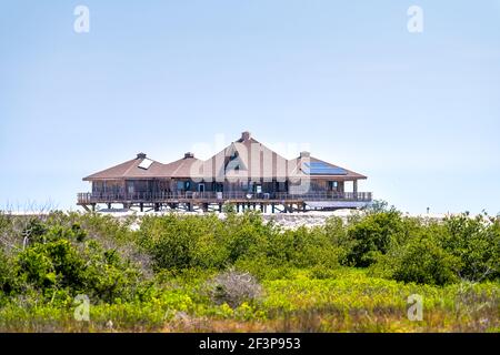 Ein braunes Stelzenhaus auf Stelzen am Ozean des Atlantikstrandes in Palm Coast, Florida mit erneuerbaren Sonnenkollektoren für Strom p Stockfoto