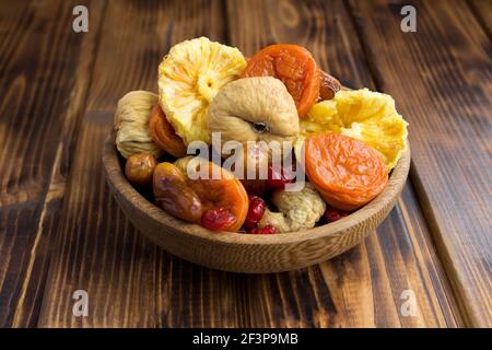Nahaufnahme von verschiedenen getrockneten Früchten im braunen Bogen Die hölzerne Oberfläche Stockfoto