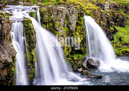 Grundarfjordur, Island Kirkjufell Wasserfall in der Nähe glatte lange Exposition Wasser auf Snaefellsnes Halbinsel mit grünem Gras im Sommer Stockfoto