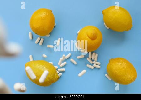 Vitamin C Kapseln.Weiße Kapseln von Vitamin, Zitronen auf einem blauen Hintergrund gesetzt.Zitrusfrüchte und Levitation Pillen.Prävention von Erkältungen und Grippe Stockfoto