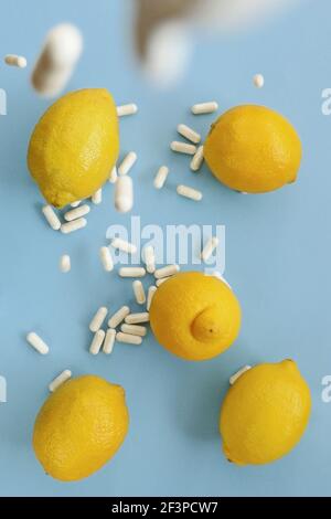 Vitamin C .Weiße Kapseln von Vitamin, Zitronen auf einem hellblauen Hintergrund gesetzt.Zitrusfrüchte und Levitation Pillen.Prävention von Erkältungen und Grippe Stockfoto