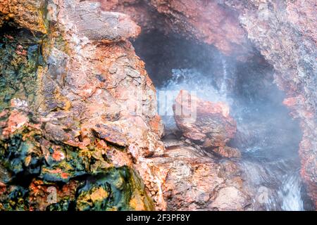 Nahaufnahme von Dampf Geysir Langzeitbelichtung Dampf in Deildartunguhver heiß Quellen in Island mit roten Felsen bunte Höhle Öffnung Loch Und kochendes Wasser Stockfoto