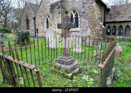 Kirche mit umliegender Friedhof und Steinkreuz Stockfoto