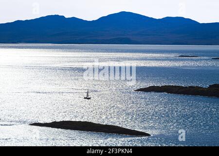 Eine Yacht im Sound of Jura, die Loch Sween von der Knapdale Peninsula nördlich von Kilmory, Argyll & Bute, Schottland betritt - Stockfoto