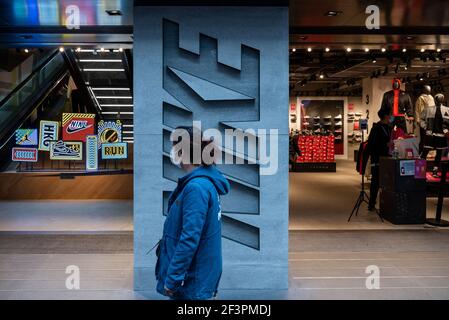 Hongkong, China. März 2021, 17th. Ein Fußgänger geht an der amerikanischen multinationalen Sportbekleidungsmarke, dem Nike Store und seinem Logo in Hongkong vorbei. Kredit: SOPA Images Limited/Alamy Live Nachrichten Stockfoto