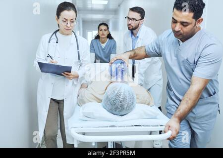 Medizinisches Team führt eine Reanimation mit Defibrillator zum Patienten durch Im Krankenhaus Stockfoto