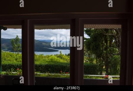 Schöne Aussicht auf Emerald Lake, gesehen durch das Fenster eines Resorts am Stadtrand von Ooty (Tamil Nadu, Indien) Stockfoto