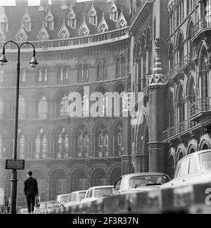 ST PANCRAS CHAMBERS, LONDON. Die Südfassade des Bahnhofs mit einem Mann, der neben einer Reihe geparkter Autos auf dem Bürgersteig entlang läuft. Datumsbereich 1960-1972 Stockfoto