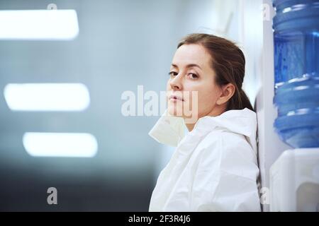 Junge Ärztin in Uniform stehend am Krankenhausflur mit Nachdenkliche Sicht Stockfoto