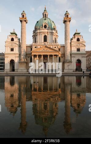 Kupferkuppel, barocke Rokoko St. Charles Kirche, nach Norden, mit zentralen Säulen und Triumphturm Pavillons mit spiralförmigen Reliefs , reflec Stockfoto