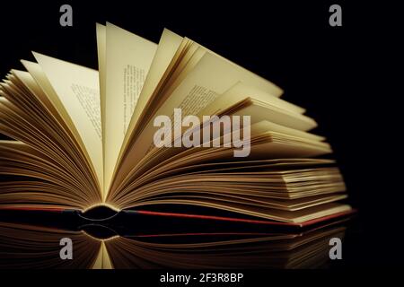 Altes Buch vor schwarzem Hintergrund Stockfoto